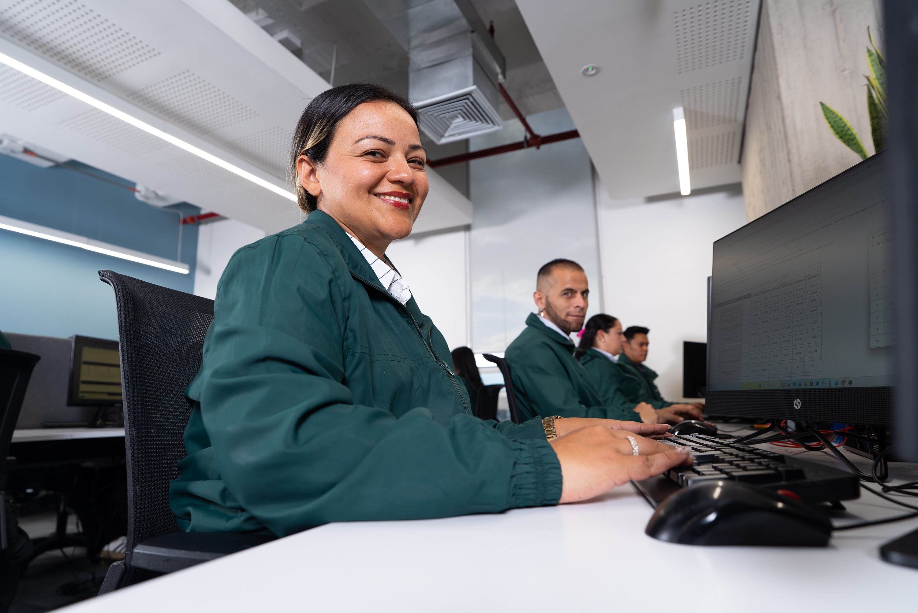 Empleada sonriendo en su puesto de trabajo.