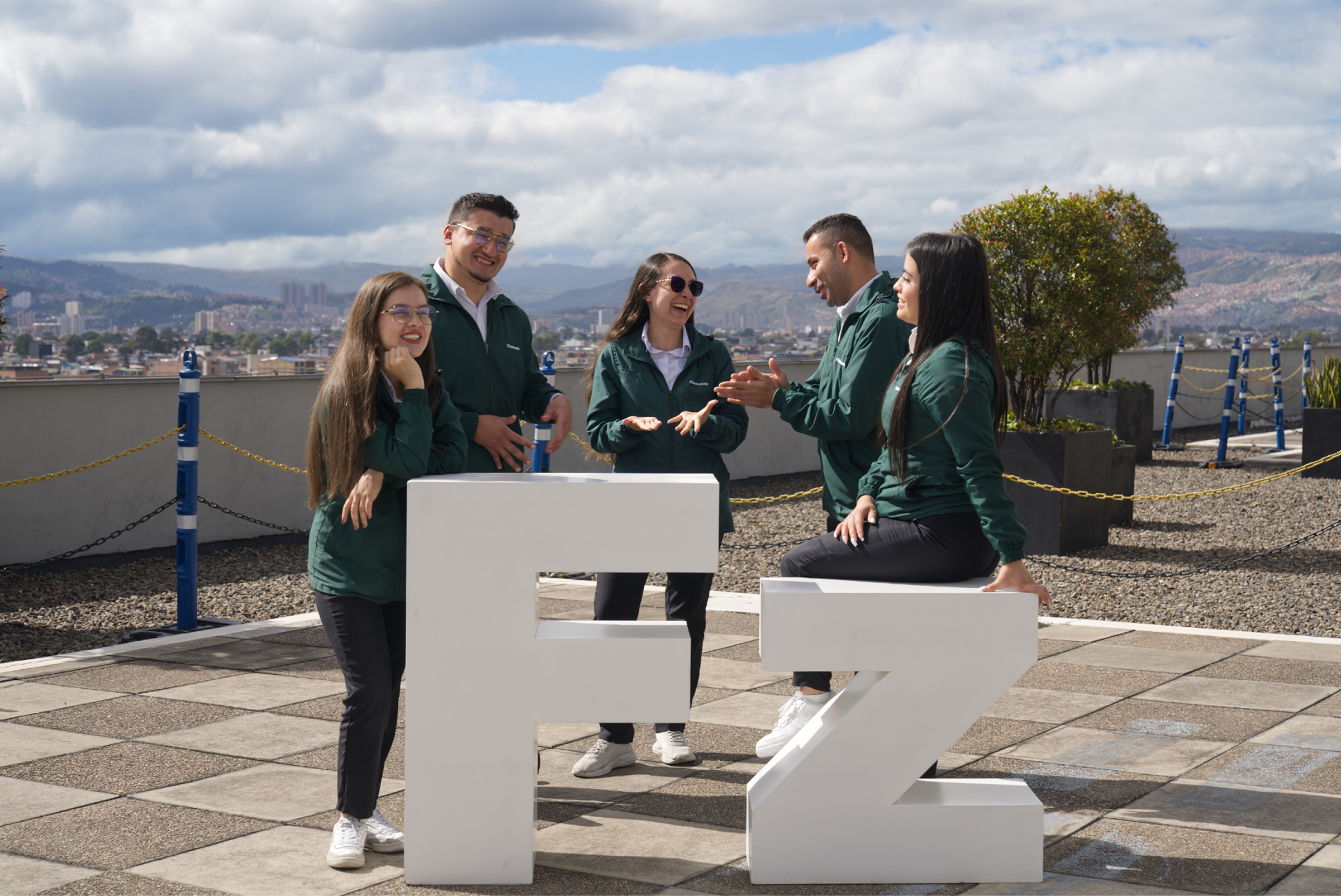Empleados conversando junto a las letras F y Z de Finanzauto.
