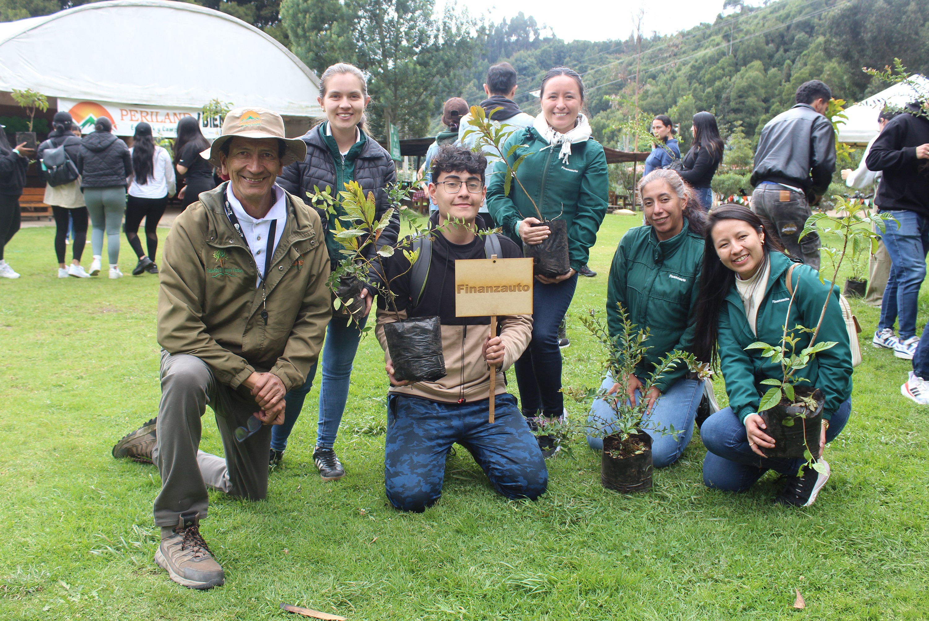 Empleados participando en una jornada de siembra de plantas en un área verde.
