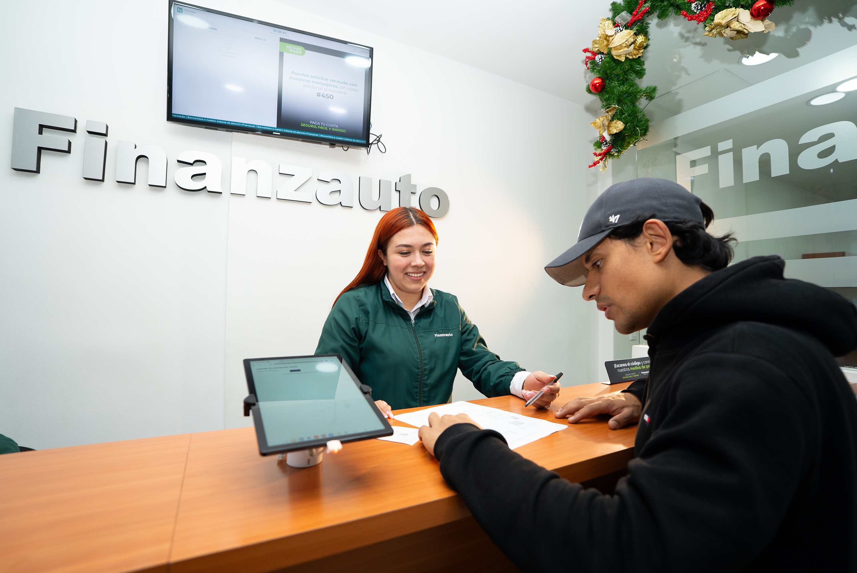 Empleada mostrando documentos a un cliente.