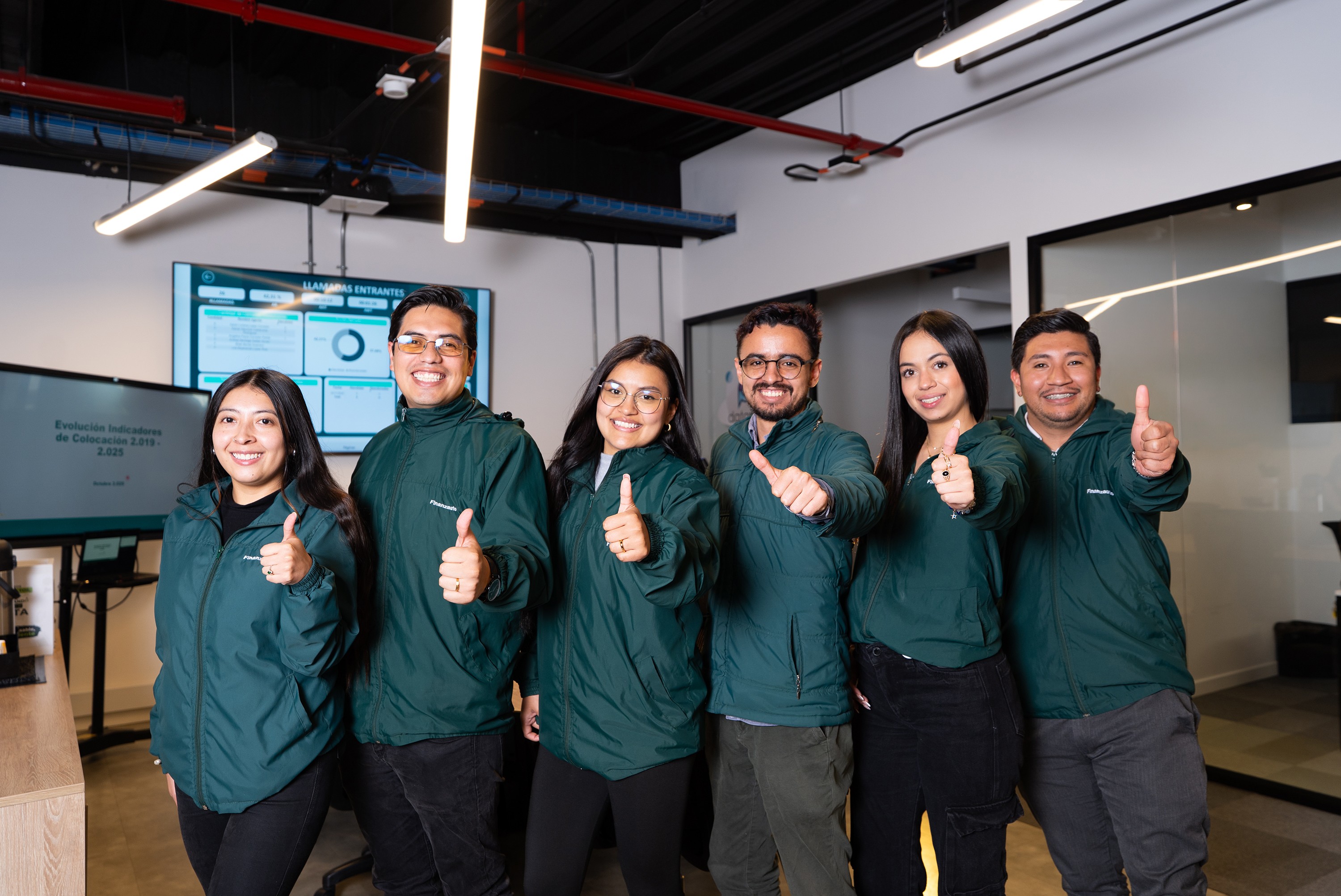 Empleados levantando el pulgar mientras sonríen a la cámara.