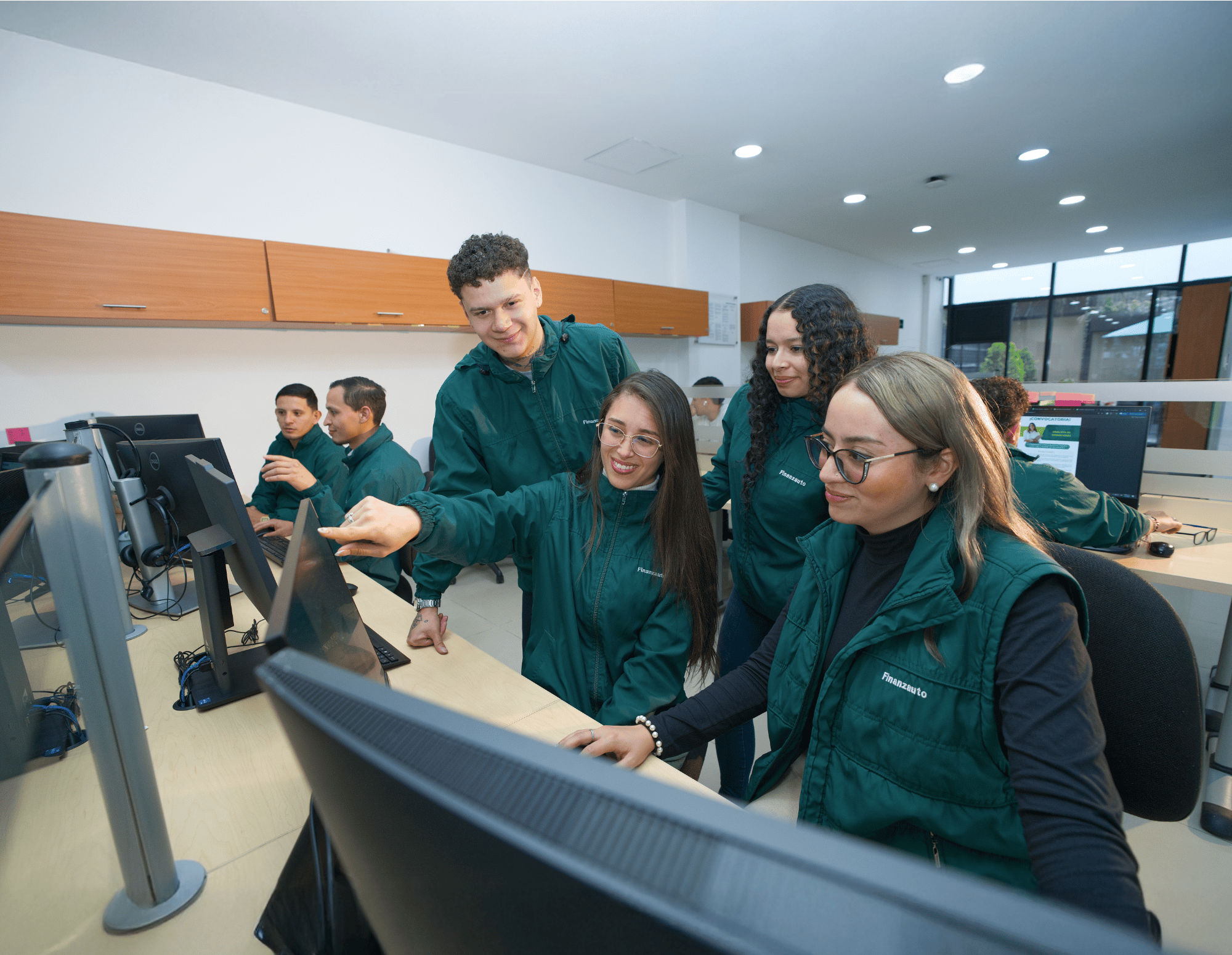 Empleados revisando información en una computadora.