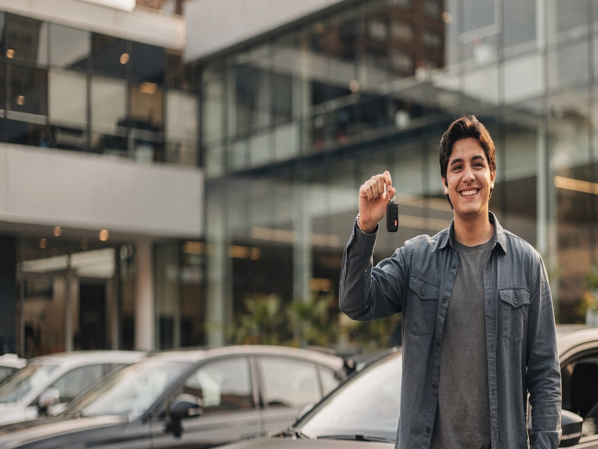 Cliente feliz mostrando la llave de su nuevo auto.