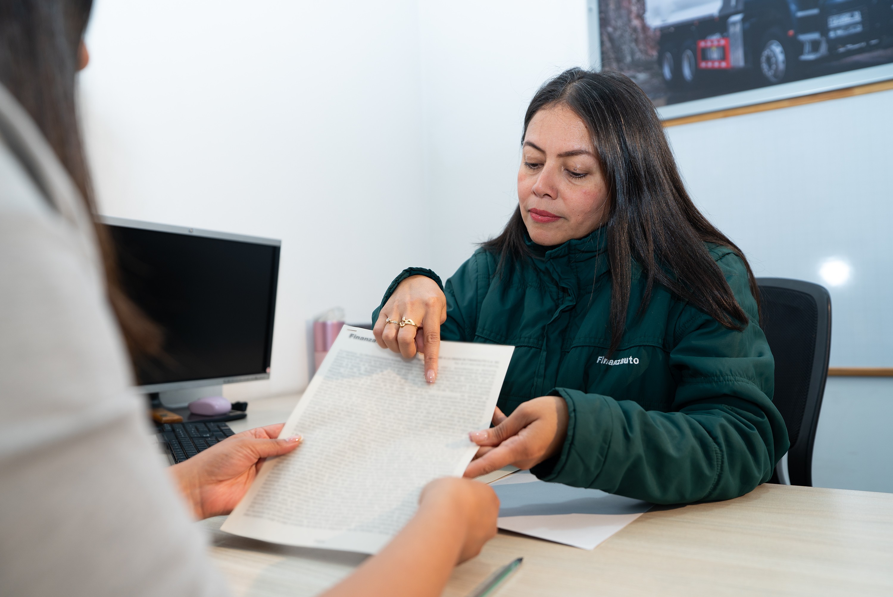 Empleada señalando información en un documento.